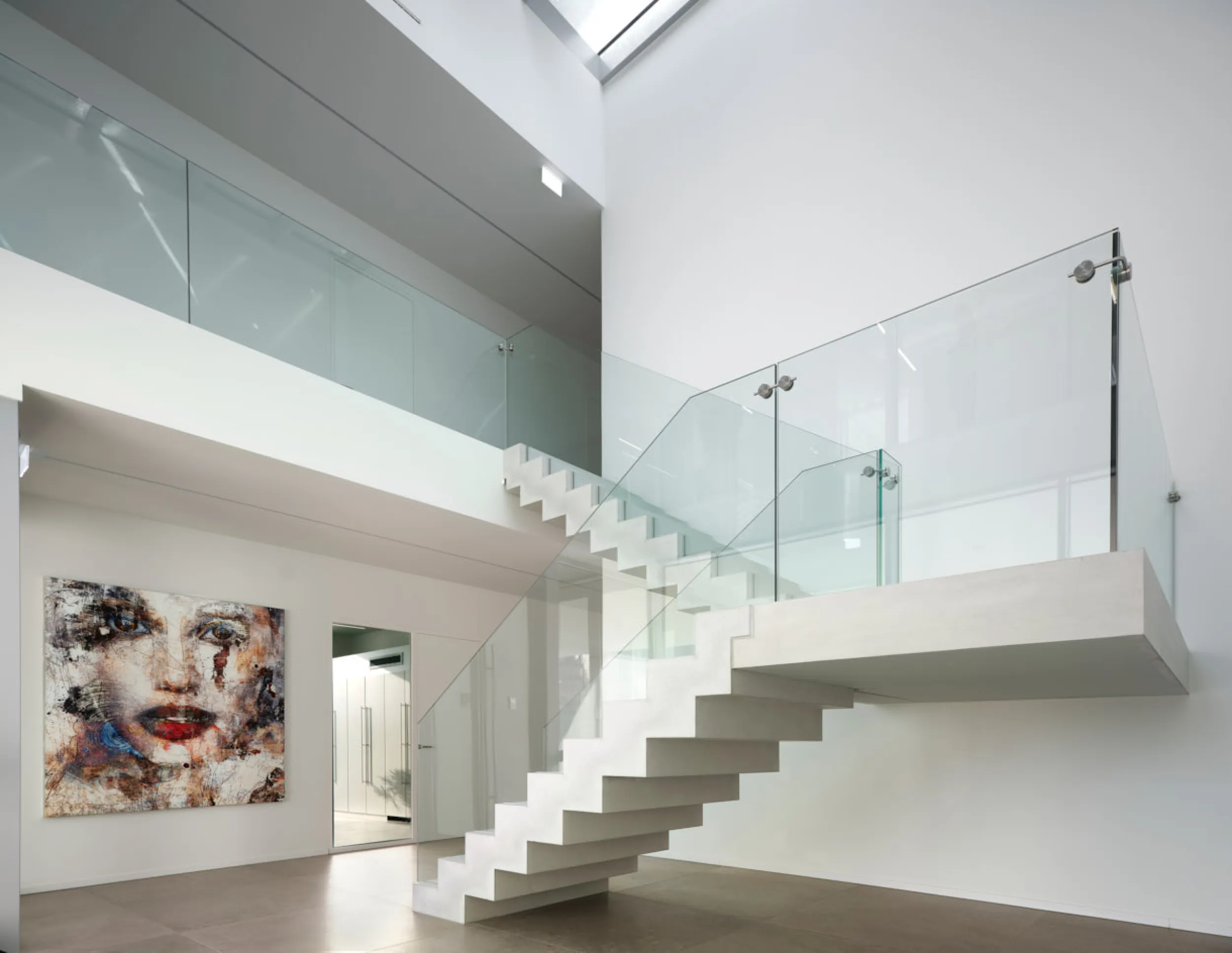Witte trap met glazen balustrade in moderne woonkamer