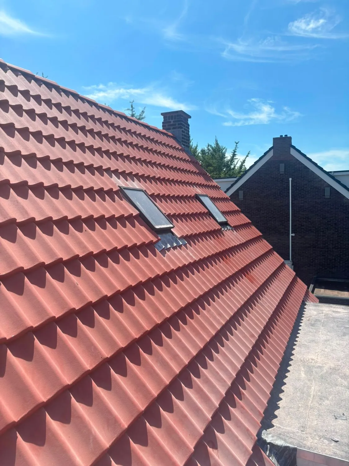 Dubbele dakrenovatie met rode pannen