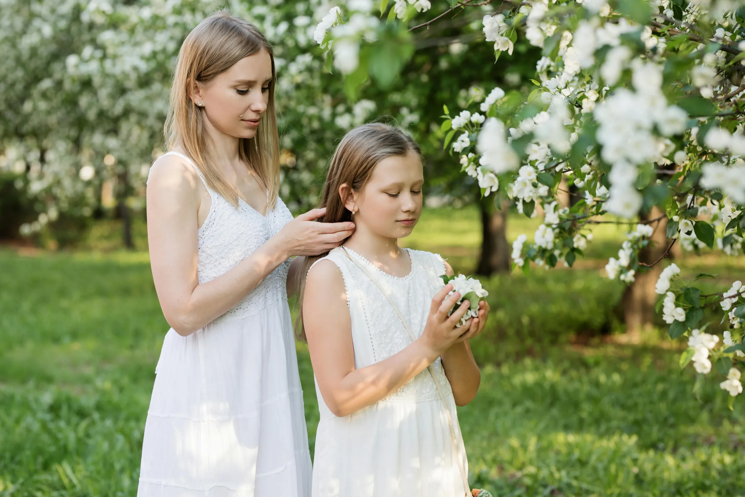Meisje en vrouw in witte kleding, feestelijk aangekleed voor het vormsel in de kerk