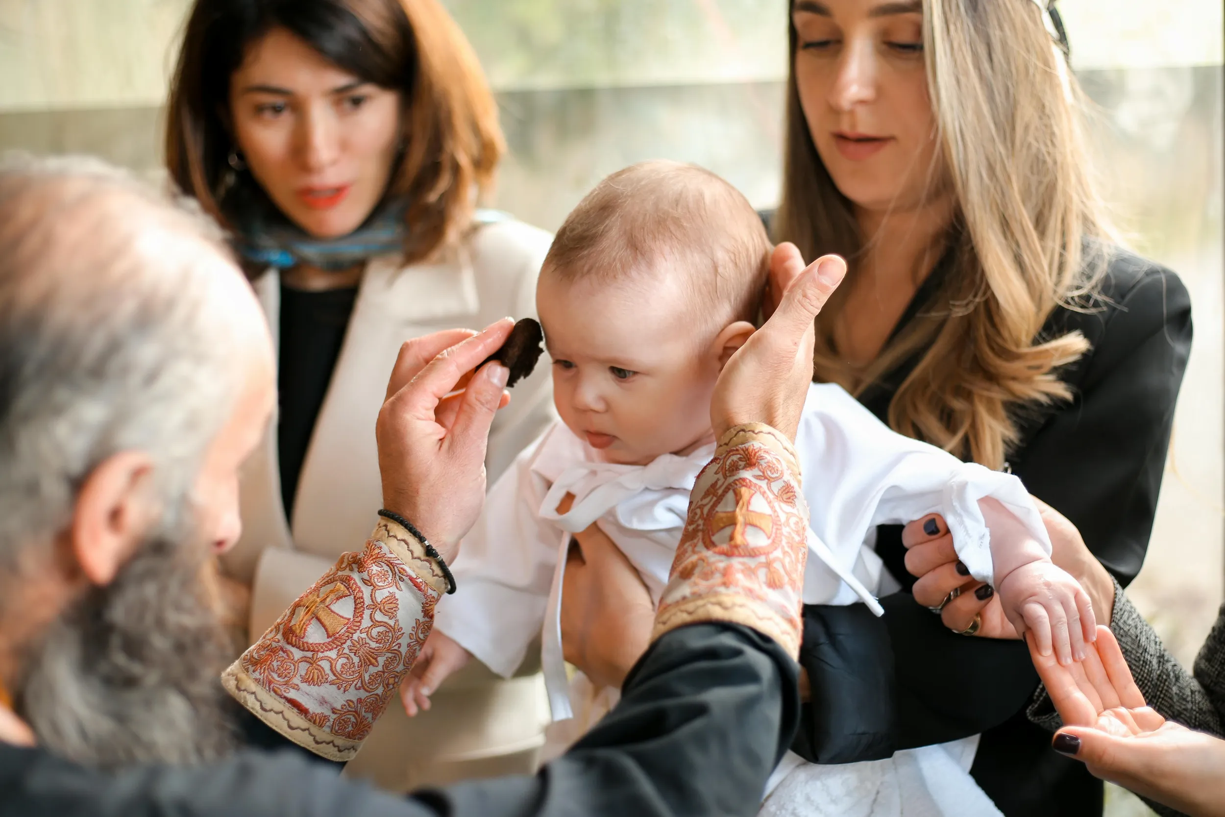 Baby wordt gedoopt tijdens een ceremonie in de katholieke kerk, waar vaak peetouders aan worden verbonden