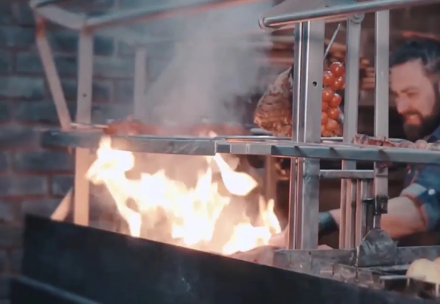 Vuur komt van een houtskoolgrill af.