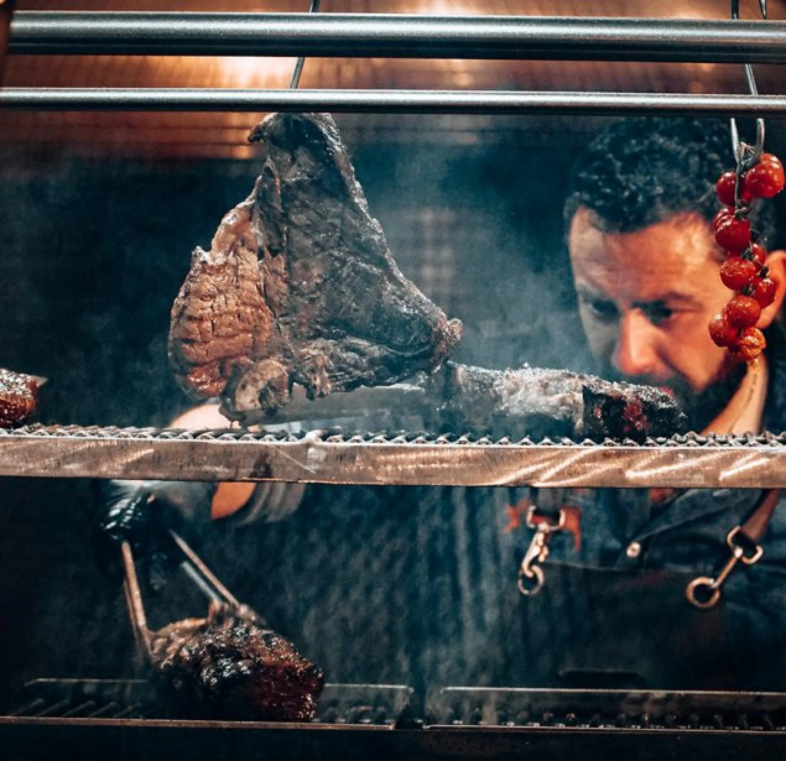 Man grilt tomahawk op de houtskoolgrill.