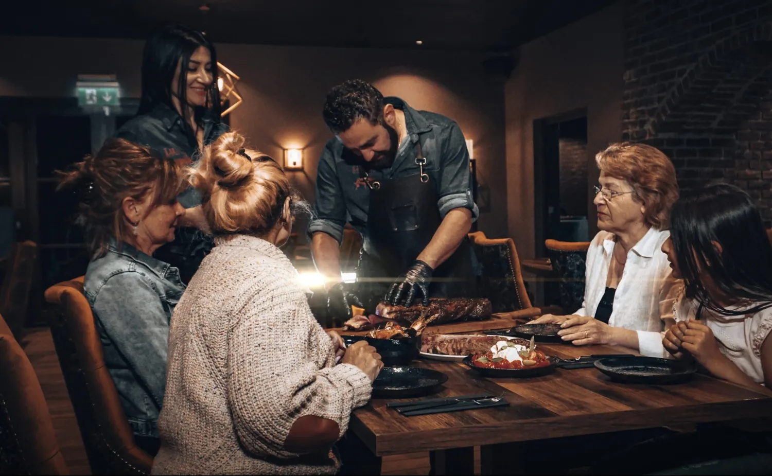 Man snijdt biefstuk aan tafel.