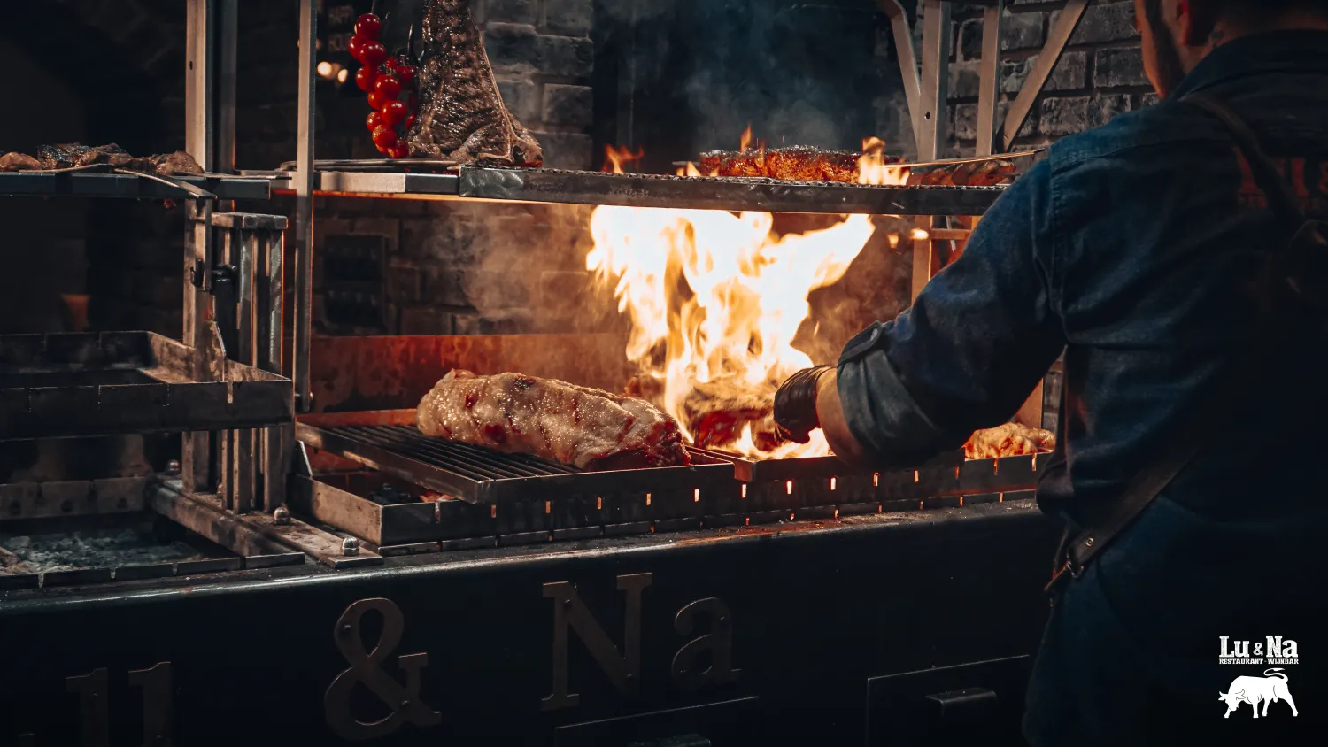 Man grilt stukken vlees op een houtskoolgrill.
