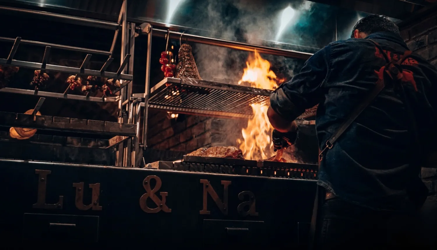 Chef grilt vlees op de houtskoolgrill