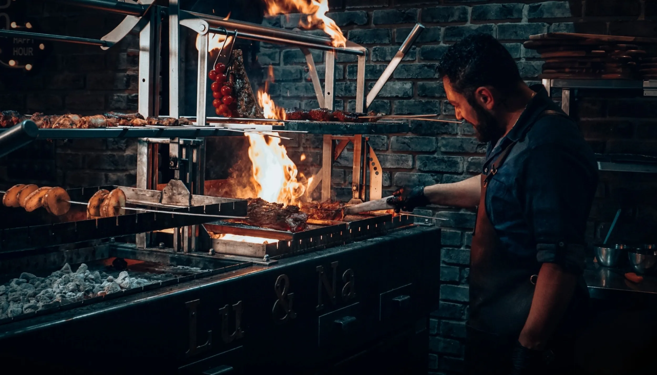 Man grilt vlees op een houtskoolgrill