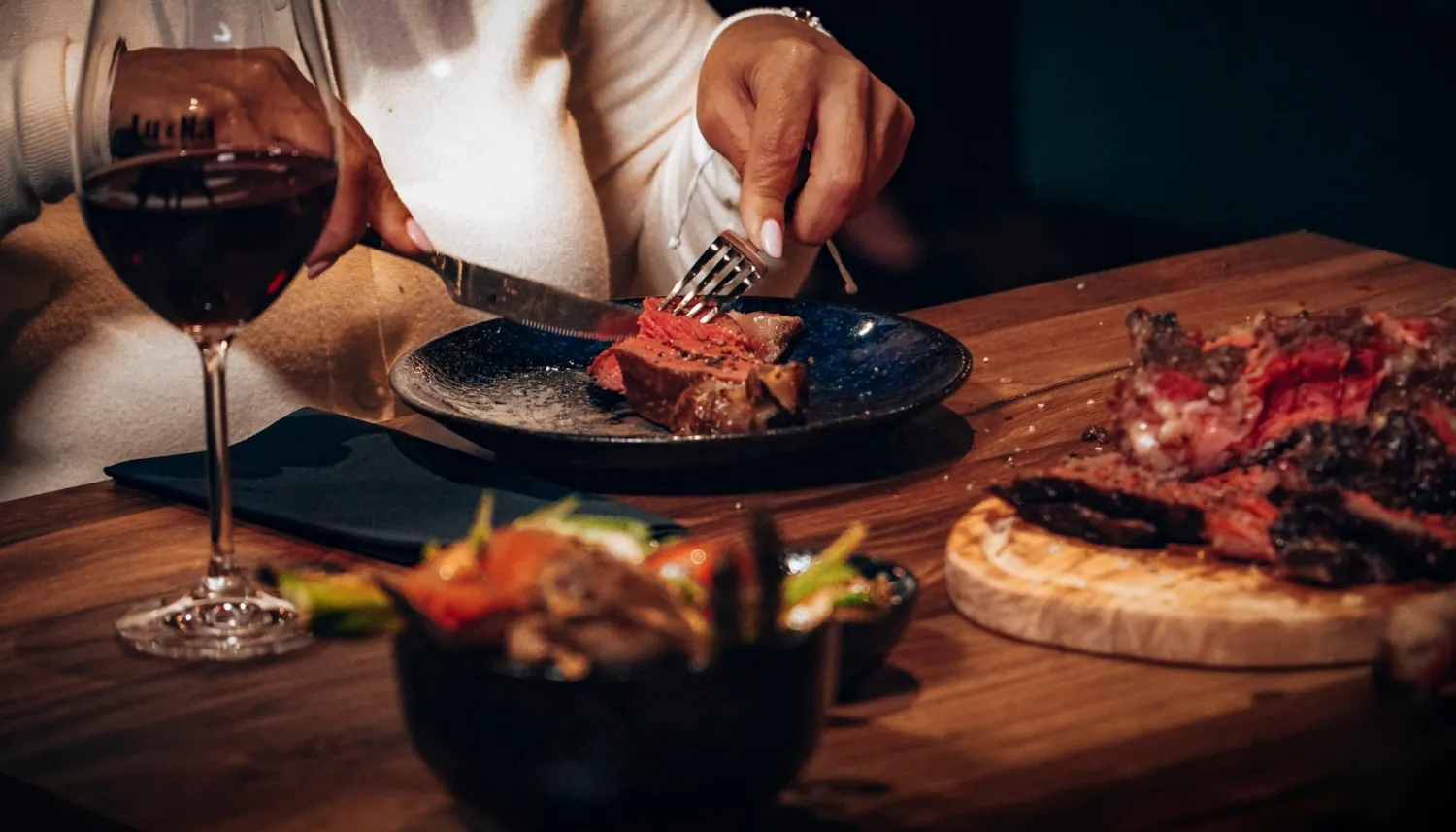 Restaurantgast snijdt een gegrilde steak aan