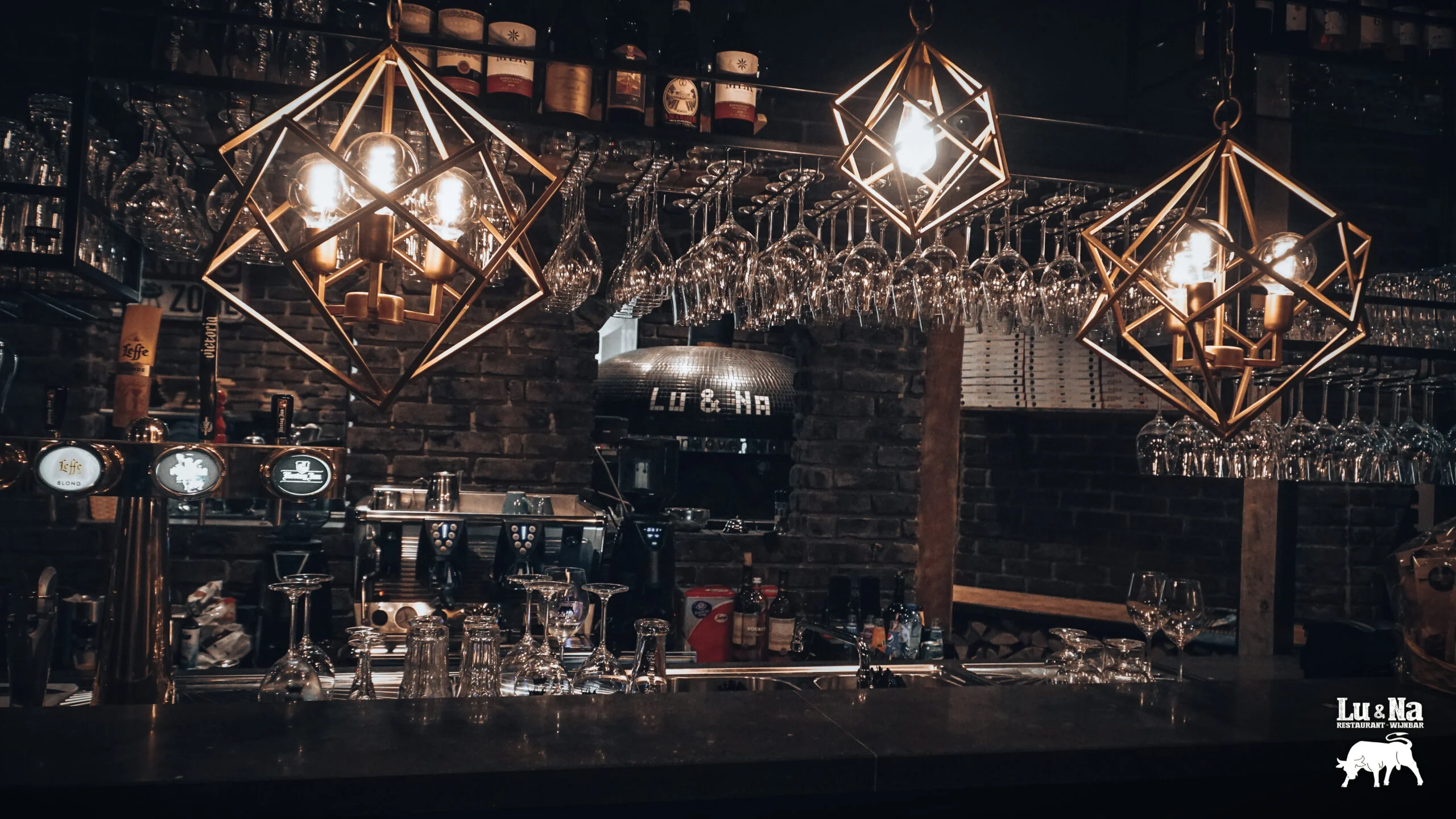 Wijnbar met hangende wijnglazen in een restaurant.