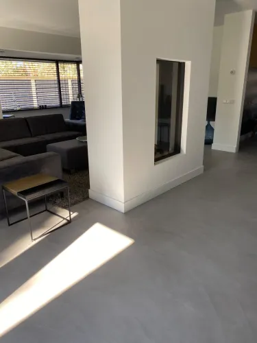 Gietvloer in woonkamer bij open haard